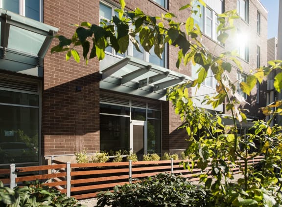 a brick building with a white awning and a wooden fence in front of it