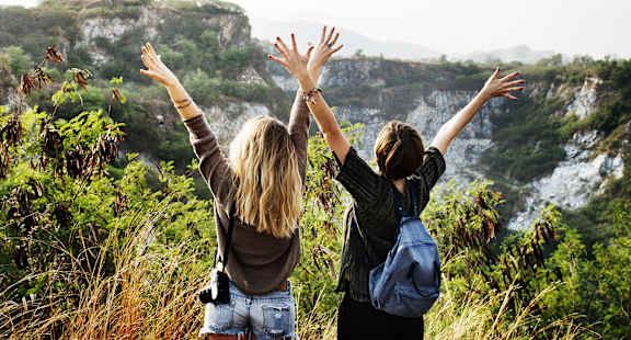 women with hands raised over ledge