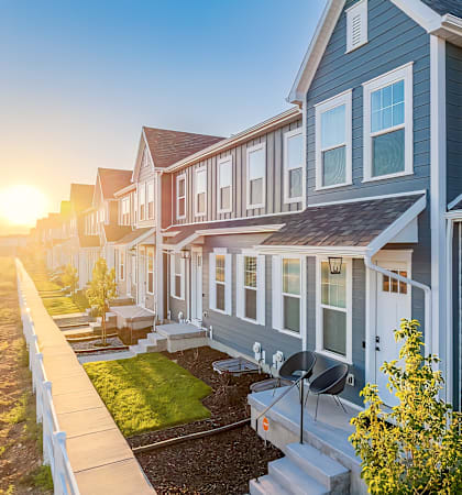 a row of houses with the sun shining in the background