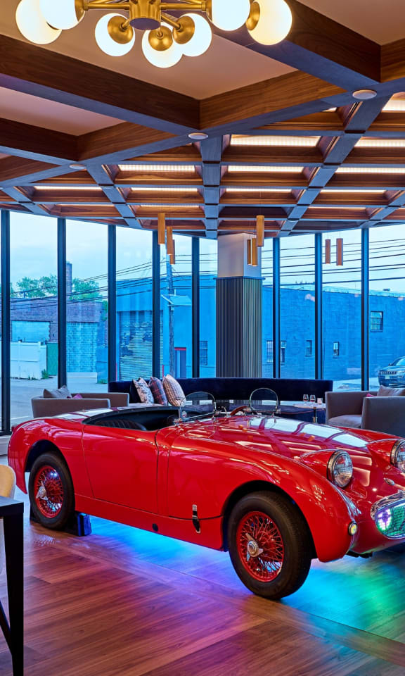 a room with a red convertible car in the middle of it at Dey & Bergen, Harrison, 07029