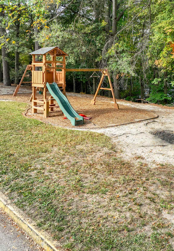 A playground with a green slide and a sign that says at Waverly Manor Townhomes, Georgia, 30071