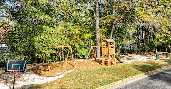 A playground with a basketball hoop and a slide.at Waverly Manor Townhomes, Norcross, GA 30071
