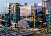 Thumbnail 9 of 24 - A cityscape with a highway and multiple buildings including a large one with the word "Revance" on it.