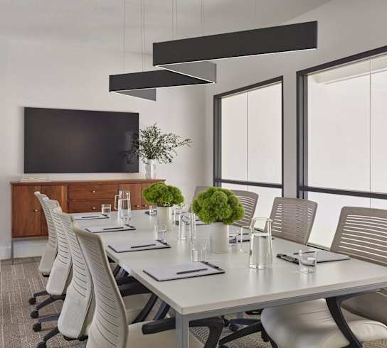 A conference room with a long table and chairs.