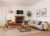 Thumbnail 2 of 8 - A living room with a fireplace, a couch, a chair, and a coffee table.