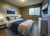 Thumbnail 7 of 8 - A bedroom with a large bed and a painting on the wall.