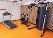 Thumbnail 10 of 16 - a gym with a treadmill and weights on the floor