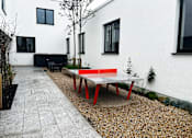 Thumbnail 15 of 16 - a ping pong table in the courtyard of a house
