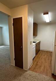 A kitchen with a white refrigerator and a stainless steel sink.
