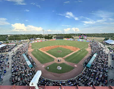 A baseball stadium is filled with fans watching a game.