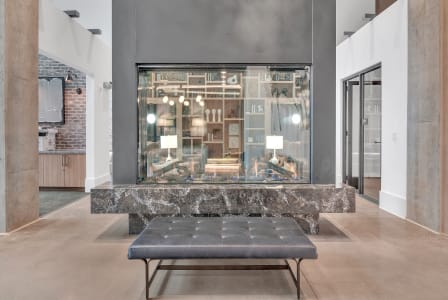 a large glass display case in a lobby with a bench