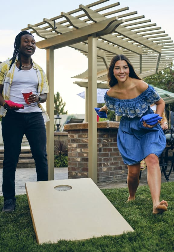 two women playing a game of frisbee on a lawn