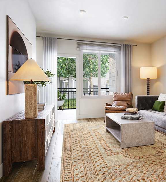A living room with a grey couch, a coffee table, and a large mirror on the wall.