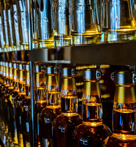 a shelf filled with bottles of alcohol in a bar at Coda on H Apartments, District of Columbia 20002
