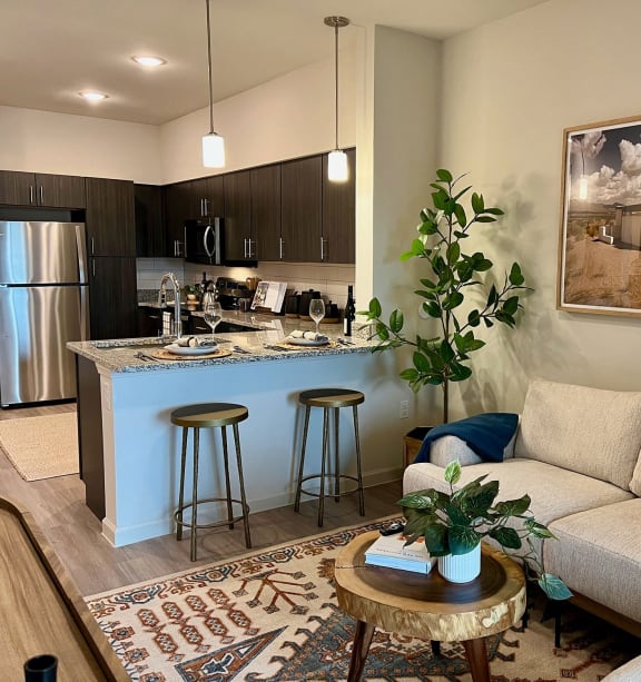 a living room with a couch and a kitchen with a bar