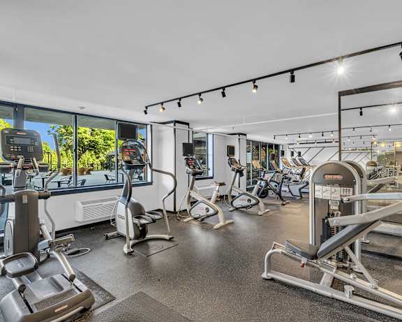 A gym with a variety of exercise equipment including treadmills, stationary bikes, and weight machines at PREMIER @ CITY LINE, Philadelphia, Pennsylvania