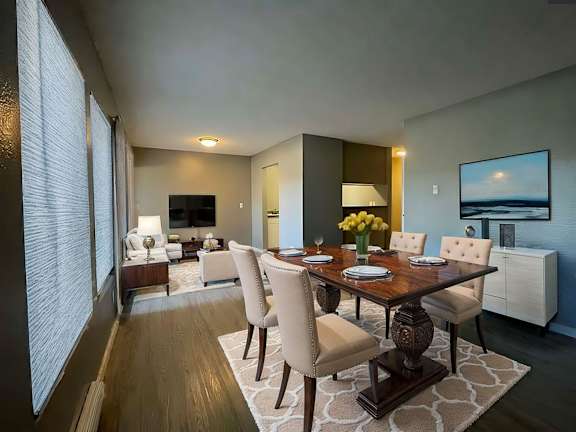 A modern dining room with a wooden table and chairs.