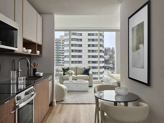 a kitchen and dining room with yellow chairs and a black table at AVE Hamilton Green - 25 Cottage Apartments, White Plains ,New York, 10601
