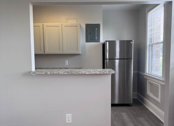 A small kitchen with a refrigerator, a microwave, and a cabinet.