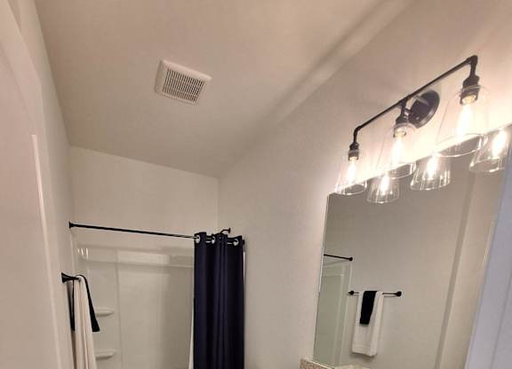 a bathroom with a shower and a sink and a mirror