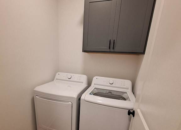a laundry room with two washers and a dryer in it