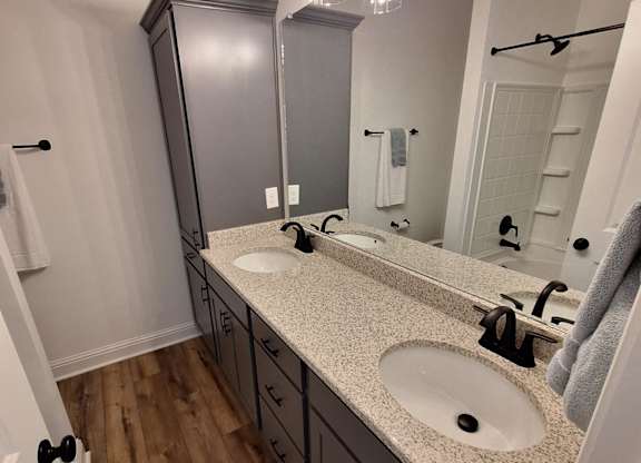 a bathroom with a sink and a mirror and a wood wall