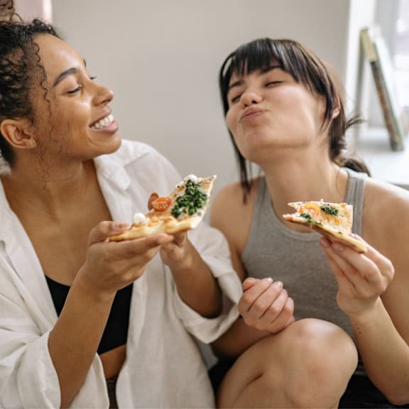 East Lansing Apartments | Students at Michigan State University eat pizza at apartment