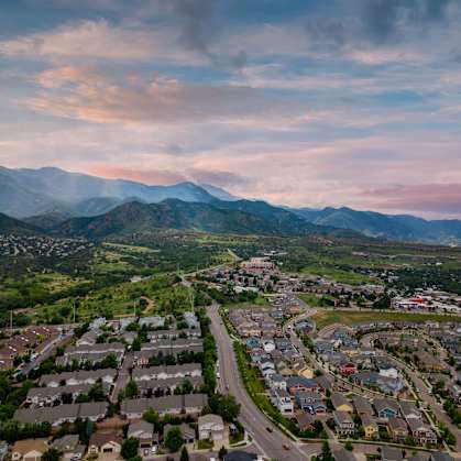 A suburban neighborhood with houses and a mountain range in the background.