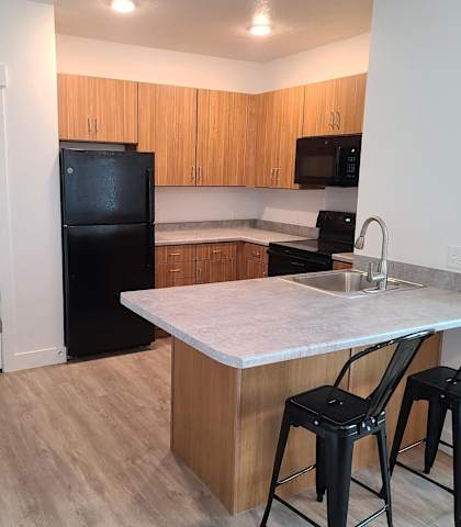 a kitchen with a island and a black refrigerator