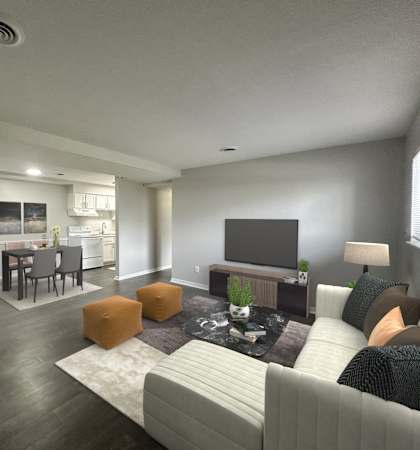 A modern living room with a grey couch, a fireplace, and a television.