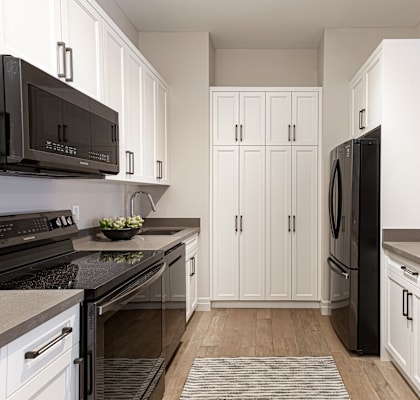 a renovated kitchen with white cabinets and black appliances