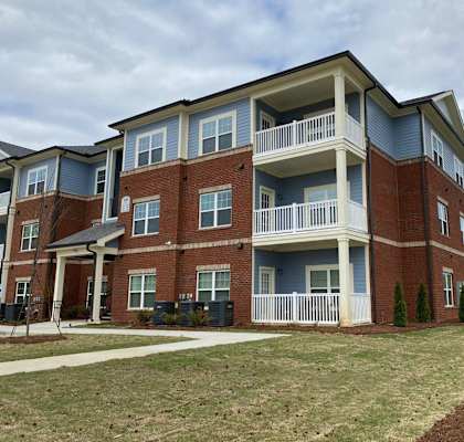 a large brick building with a sidewalk in front of it
