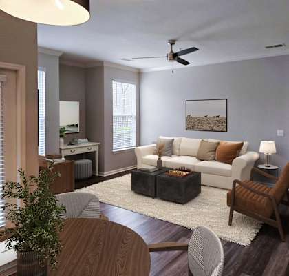 A living room with a white couch and a painting on the wall.