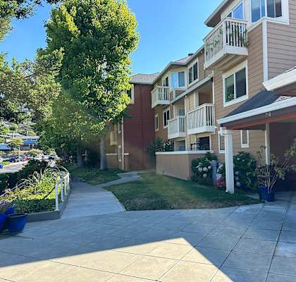A sunny day at a residential building with a clear blue sky.