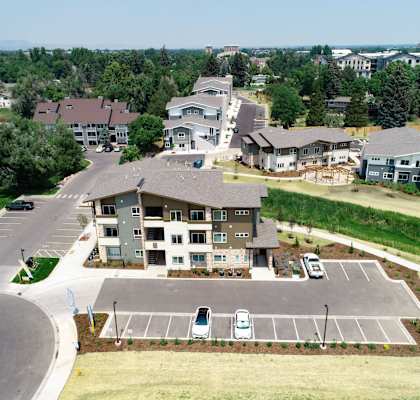 an aerial view of a large housing complex with cars parked in the parking lot