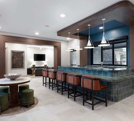 A modern bar area with a round table and bar stools at AVE Paradise Valley