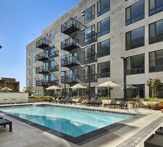 A large building with a pool in front of it.