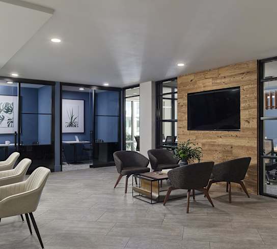 A modern living room with a stone wall and a flat screen TV.