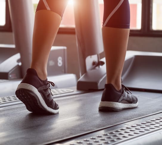 a woman walking on a treadmill in a gym