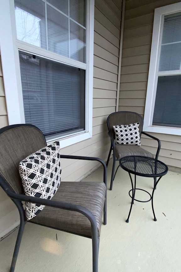 A patio with a chair and a small table.