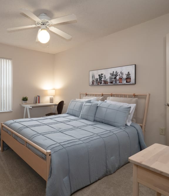 a bedroom with a large bed and a ceiling fan at The Fountains Apartments, Pensacola, Florida