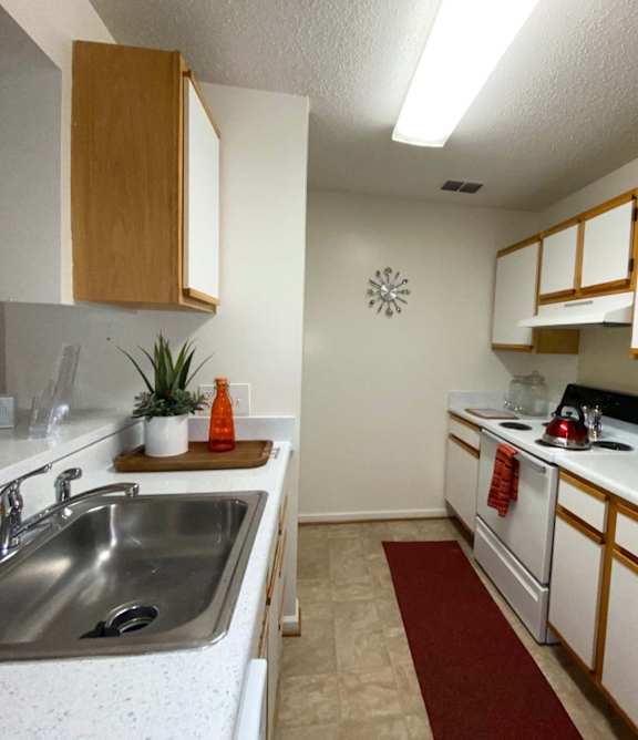 A kitchen with white cabinets and a white fridge.