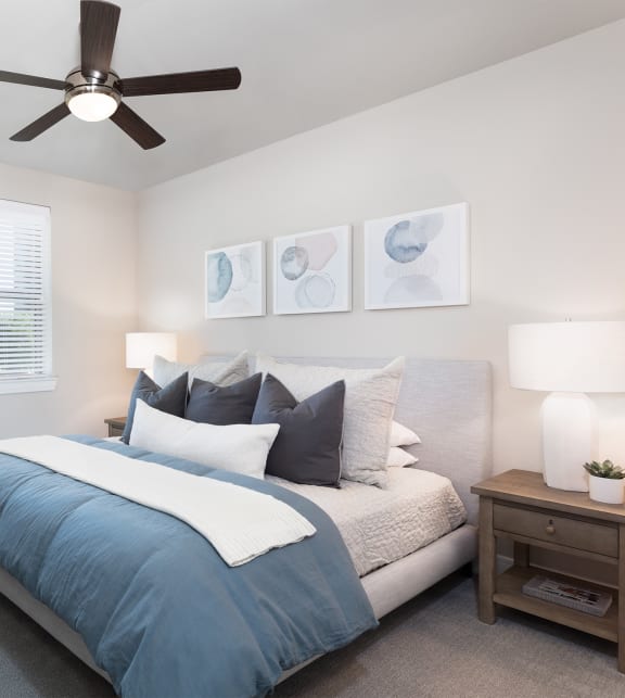 a bedroom with a large bed and a ceiling fan