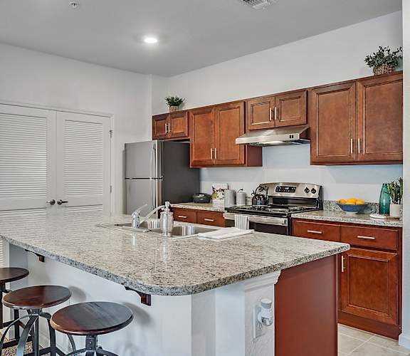 a kitchen with a granite counter top and wooden cabinets
