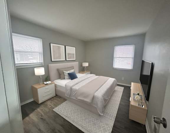 A bedroom with a bed, nightstands, and a window.
