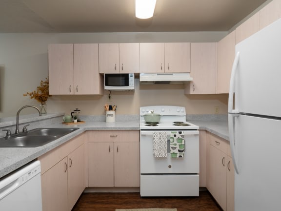 a kitchen with white appliances and white cabinets at The Fountains Apartments, Pensacola, FL, 32514