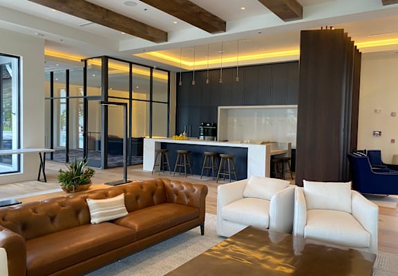 A brown leather couch with a white cushion sits in a modern living room.
