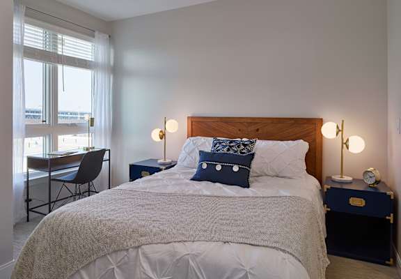 A bedroom with a large bed and a chair by the window. at 11 Cooper Apartments, Camden,New Jersey, 08102