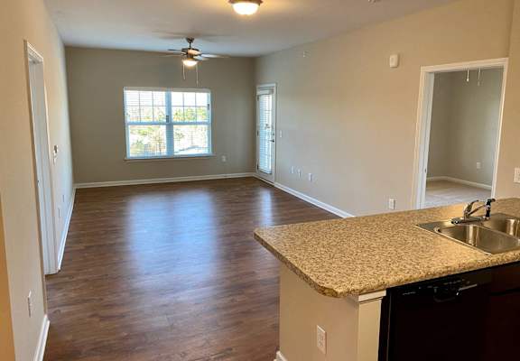 an empty kitchen and living room with a large window