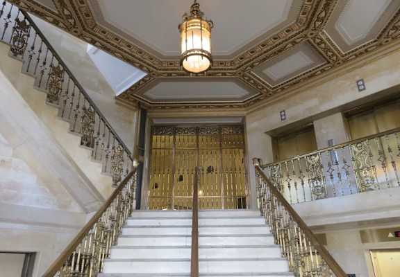 A staircase with a metal railing and a light hanging from the ceiling.